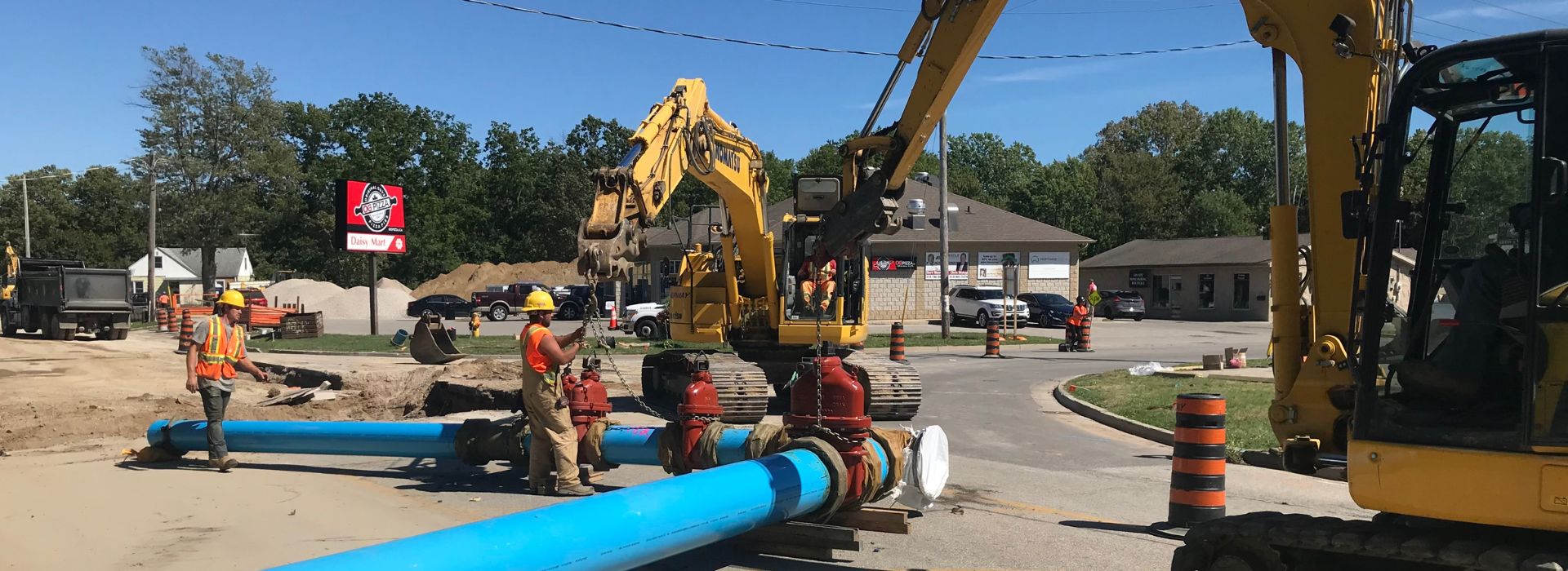 Construction workers installing sewer piping for roads