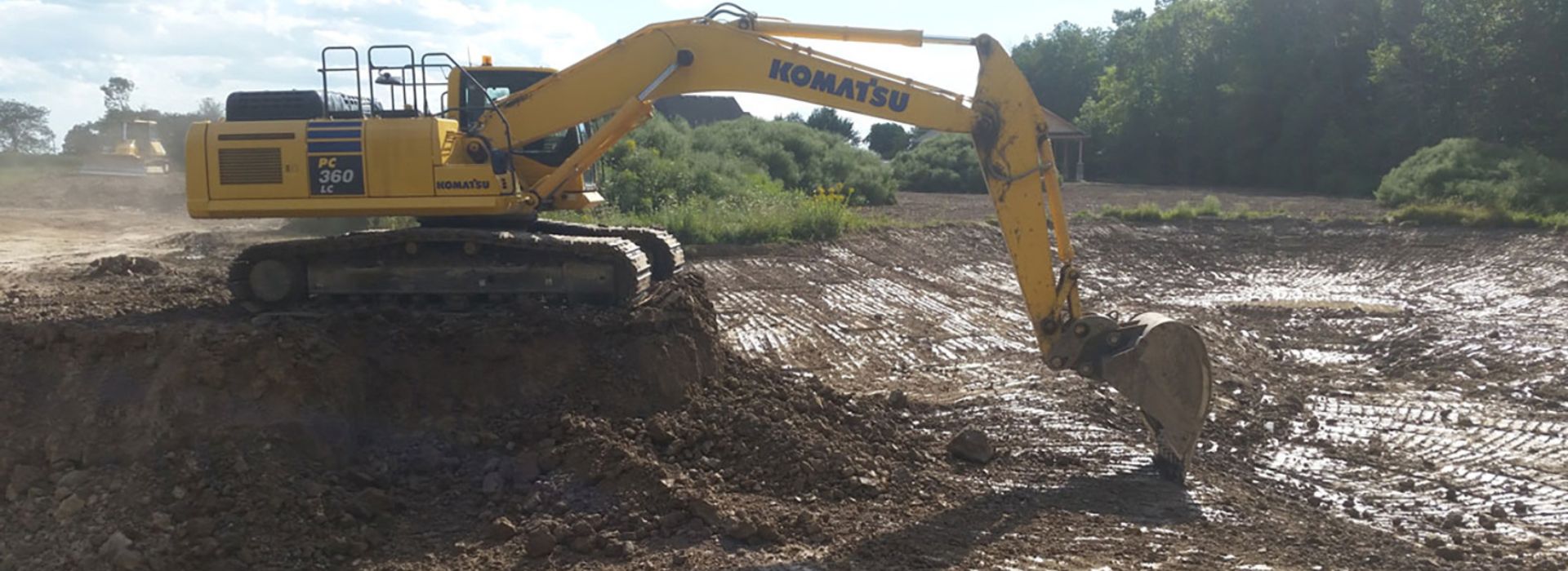 large bulldozer excavating a drained pond